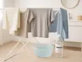 Suszone ubrania na suszarce, miska z wodą i butelka octu. Koniec ze stęchlizną, czas na świeżość!