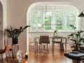 Eklektyczny salon z jadalnią, gdzie nowoczesne meble i rośliny tworzą przytulną atmosferę.
