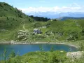 Sentiero per il lago di Erdemolo, con rifugio e montagne sullo sfondo.