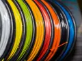 Kolorowy filament do druku 3D, nawinięty na szpulki. Zastanawiasz się, filament co to? To materiał do tworzenia trójwymiarowych obiektów.