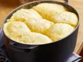 Frisch gebackene Dampfnudeln in einem schwarzen Topf. Ein köstliches Dampfnudel Rezept, das du unbedingt ausprobieren musst!