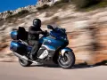Motocyklista w kasku przemierza malowniczą trasę, odkrywając różne rodzaje turystyki.