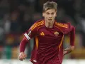 Piłkarz AS Roma w bordowej koszulce z żółtymi pasami, gotowy do gry przeciwko Genoa CFC.
