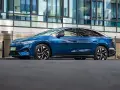 Niebieski Volkswagen ID.7 zaparkowany przed nowoczesnym budynkiem.