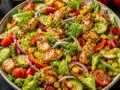 Pyszna sałatka z mix sałat, grillowanym kurczakiem, pomidorami, ogórkiem, papryką i kukurydzą. Idealna na lekki posiłek.