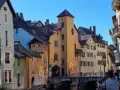Magnifique journée pour visiter Annecy à pied. Les maisons colorées bordent le canal, un pont de pierre relie les rives.