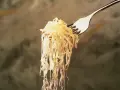 Un tenedor levanta una porción de chucrut, evocando su origen ancestral en la fermentación de la col.