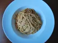 Spaghetti Napoli z sosem pomidorowym i parmezanem, podane w białej głębokiej misce.