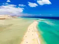 Plaża na Fuerteventurze, z turkusową wodą i piaszczystym cyplem, zachęca do wypoczynku. Czy to Fuerteventura czy Teneryfa, widok zapiera dech.