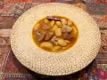 Plato de judiones de la granja receta tradicional, con trozos de tocino y carne en un caldo sabroso.