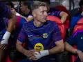 Robert Lewandowski w meczu FC Barcelona – Valencia CF, siedzi na ławce z bandażem na ręce, skupiony na grze.