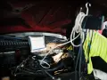 Mechanik diagnozuje problem DTC P0606 Renault za pomocą laptopa pod maską.