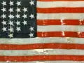 Pierwsza flaga USA, zniszczona i wyblakła, z 13 gwiazdami i pasami, świadectwo historii.