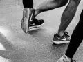 Gambe di corridori in azione, con particolare attenzione al consumo delle scarpe sportive Nike.