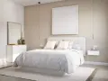 Una serena habitación blanca con cama vestida de blanco, mesitas de noche flotantes y un cuadro minimalista.