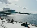 Oslo fiordy jak dojechać: nowoczesna Opera Narodowa i ludzie odpoczywający nad wodą.