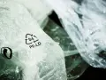 Zgniecione folie PE-LD z symbolem recyklingu. Firma stawia na recykling tworzyw sztucznych, dbając o środowisko.