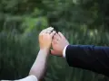 Dłonie pary z obrączkami, symbol miłości. Uniknij rozczarowania zdjęciami, wybierając sprawdzonego fotografa.