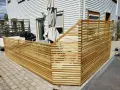 Ett modernt staket i trä som ramar in en uteplats. Perfekt för dig som vill bygga billigt staket och skapa en mysig vrå.