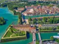 Peschiera del Garda centro storico: fortezza a stella circondata da acque turchesi, con edifici storici e un ponte.