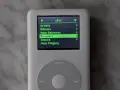 Ein iPod Classic mit dem Menü "sPot" und der Option "Playlists" hervorgehoben. Nostalgie trifft auf modernen Musikgenuss, wie ein iPod Classic mit Spotify-ähnlicher Oberfläche.