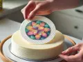 Ręce kładą kolorowy opłatek cukrowy na tort. Dekoracja z kwiatem zachwyca!