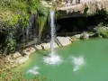 Disfrutando del baño en piscinas naturales junto a la cascada de Tobera. Un grupo de amigos se lanza al agua turquesa.