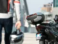 Un motociclista con casco in mano si avvicina alla sua moto. Andare in moto fa bene, un'avventura ti aspetta!