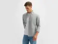 Mężczyzna w szarej koszuli i białej koszulce, prezentujący styl smart casual męski.
