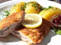 Kotlet po szwajcarsku z ziemniakami, cytryną i żurawiną. Pyszne danie na talerzu.
