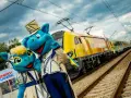 Dwa niebieskie smoki w strojach stoją obok żółtego pociągu na torach kolejowych.