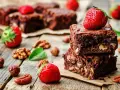 Czekoladowe brownie z orzechami i truskawkami. Pyszna przekąska, której brownie kcal nie zrujnuje diety.