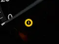 Gelbes Warnlicht mit einem Zahnrad und Ausrufezeichen im Auto-Armaturenbrett. Ein Zeichen für ein Problem mit dem Getriebe.