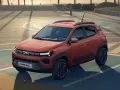 Pomarańczowy Dacia Spring na boisku. Sprawdź atrakcyjną dacia spring cena i odkryj jego możliwości.