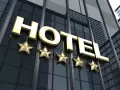 Złoty napis HOTEL i pięć gwiazdek na nowoczesnym budynku. Marzysz, jak zostać testerem hoteli w Polsce?
