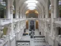 Interior del museo de artes decorativas, con arcos, balcones y vitrinas exhibiendo objetos.