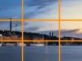 Un paysage urbain au crépuscule, avec des bâtiments historiques et des bateaux le long de l'eau. Un excellent exemple pour un tuto photographie sur la règle des tiers.