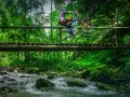 Rowerzysta na drewnianym moście nad potokiem, odkrywa nowe trasy rowerowe Zakopane.