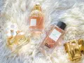 Kolekcja luksusowych perfum damskich: Daisy, Aqua Allegoria, L'Impératrice D&G i The One Dolce & Gabbana na puszystym tle.