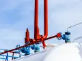 Zawory i rury przy białym zbiorniku na gaz. Zastanawiasz się, na ile wystarcza zbiornik na gaz 2700?
