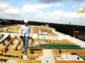 Budowlaniec w kasku na dachu w trakcie odbioru mieszkania.