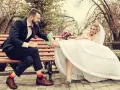 Para młoda siedzi na ławce, ona podnosi nogę w miętowych szpilkach, on uśmiecha się.