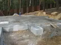Fundament płytowy w trakcie budowy, z widocznymi elementami betonowymi i zbrojeniem.