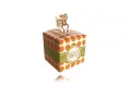 A white gift box with orange polka dots and a green ribbon, topped with a monkey cutout.