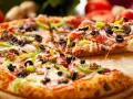 Pyszna pizza na gotowym cieście z Biedronki, z mnóstwem dodatków: mięsem, oliwkami, papryką i cebulą. Ser ciągnie się apetycznie.
