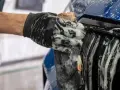 Rękawica z gąbką myje grill samochodu pokryty pianą. Pytanie: czym myć samochód? Odpowiedź: pianą i gąbką!