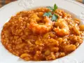 Delicioso arroz con mariscos, una de las mejores recetas de arroz. Servido en plato blanco con perejil fresco.