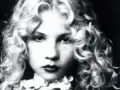 Portrait en noir et blanc d'Eva Ionesco enfant, aux boucles blondes et au regard intense.