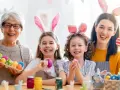 Familie feiert die Osterferien BW 2026 mit bunten Eiern und Hasenohren.