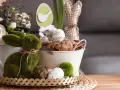Zielony, mchowy zajączek i pisanki tworzą najpiękniejsze dekoracje wielkanocne. W koszyku jajko z napisem "Happy Easter".